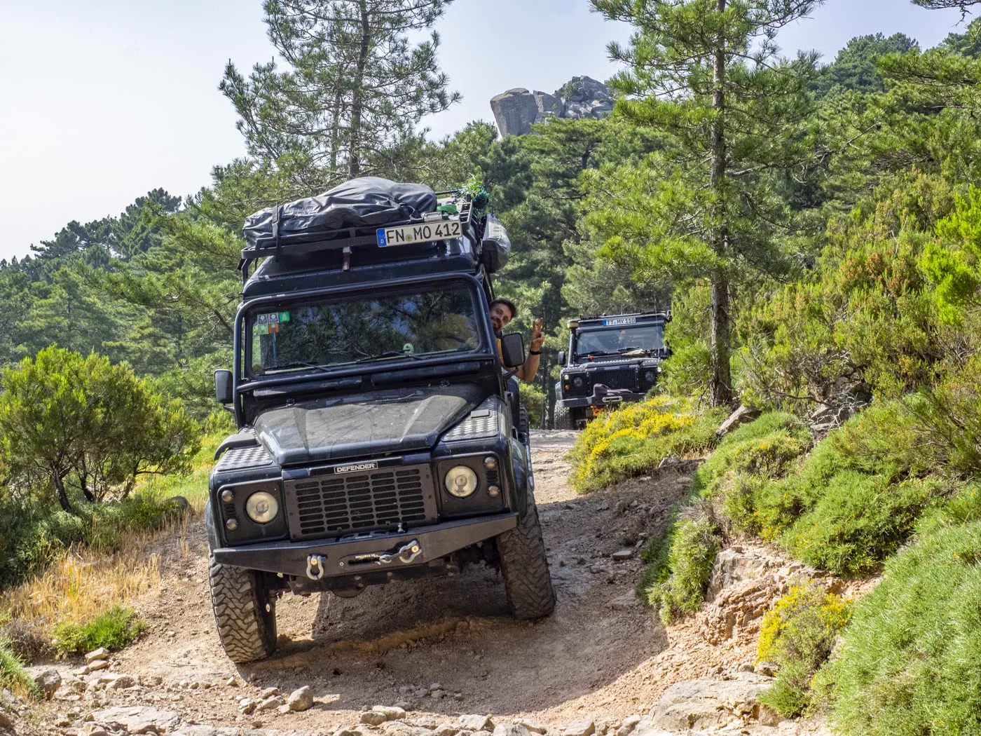 Two Defenders in convoy on a rocky track